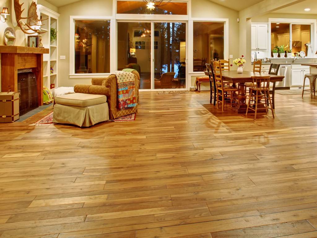 Hardwood flooring in a cozy living space with dining table, chairs, seating area, and fireplace at The Flooring Store & More Tucson